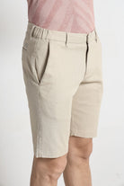 Beige shorts worn by a person on a white background