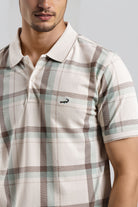 Man wearing a plaid shirt with a brand logo on a gray background