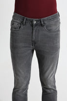 Gray jeans worn by a person on a white background
