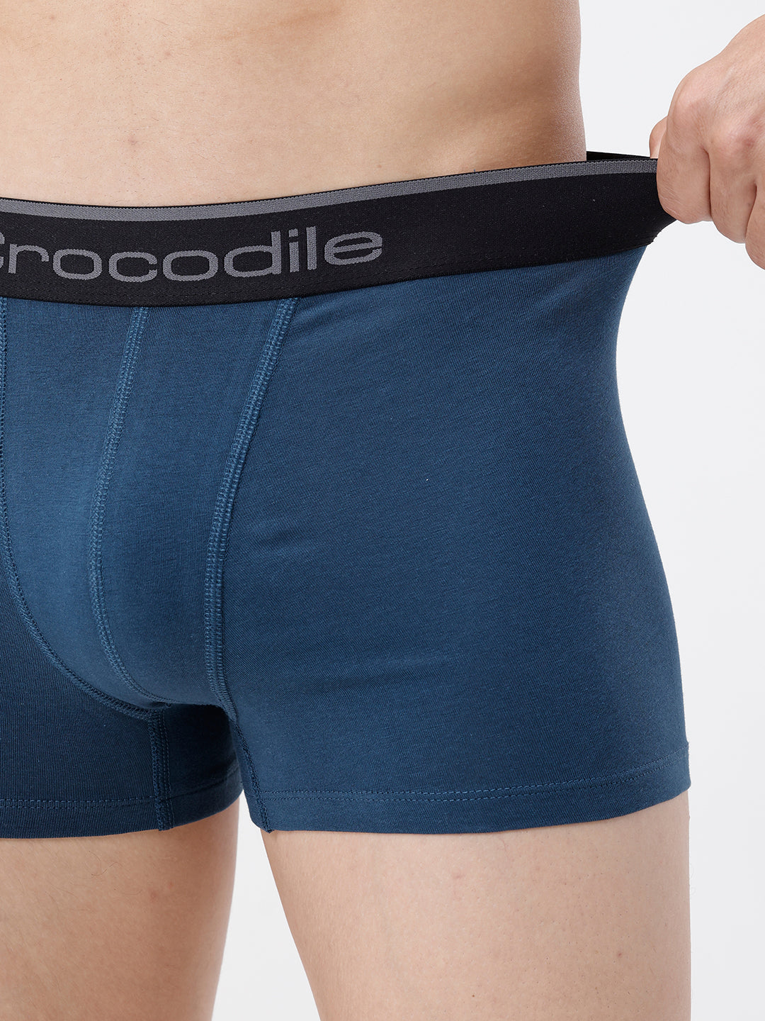 Person wearing blue boxer briefs with a black waistband featuring 'Crocodile' branding.