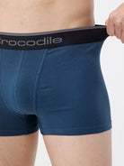 Person wearing blue boxer briefs with a black waistband featuring 'Crocodile' branding.