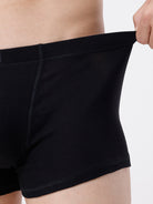 Person wearing black boxer briefs on a plain background