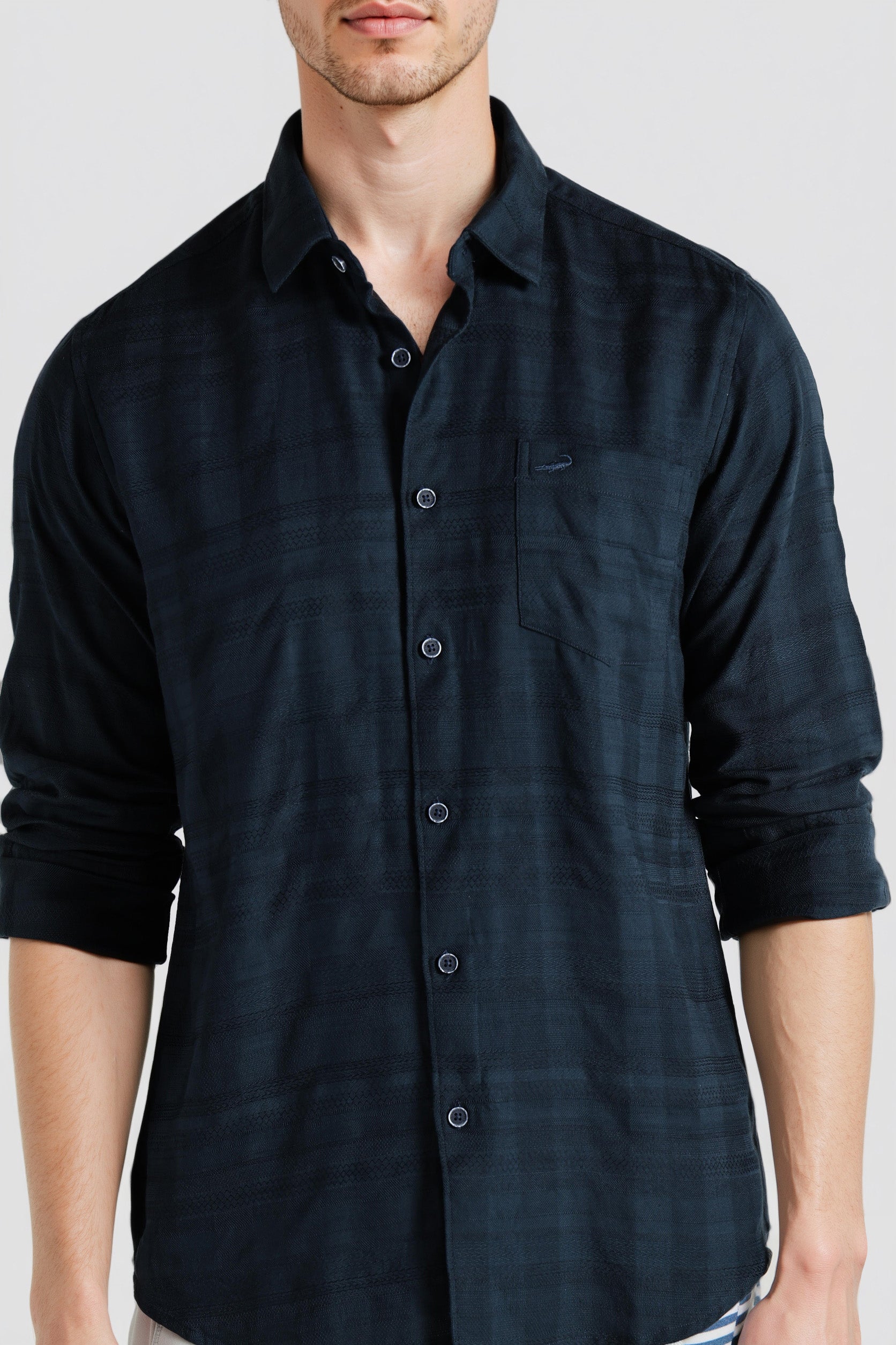 Man wearing a dark blue button-up shirt against a white background