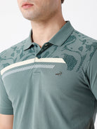 Man wearing a green iceberg green chest print slim fit polo t shirt on a light gray background
