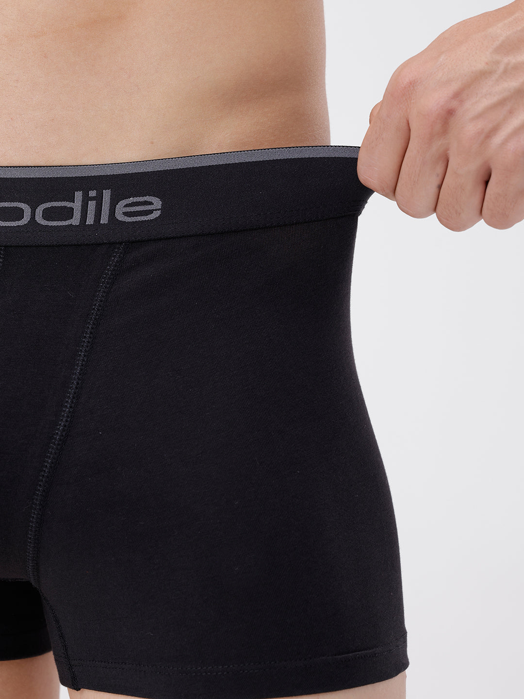 Person wearing black underwear with a visible brand logo on a plain background