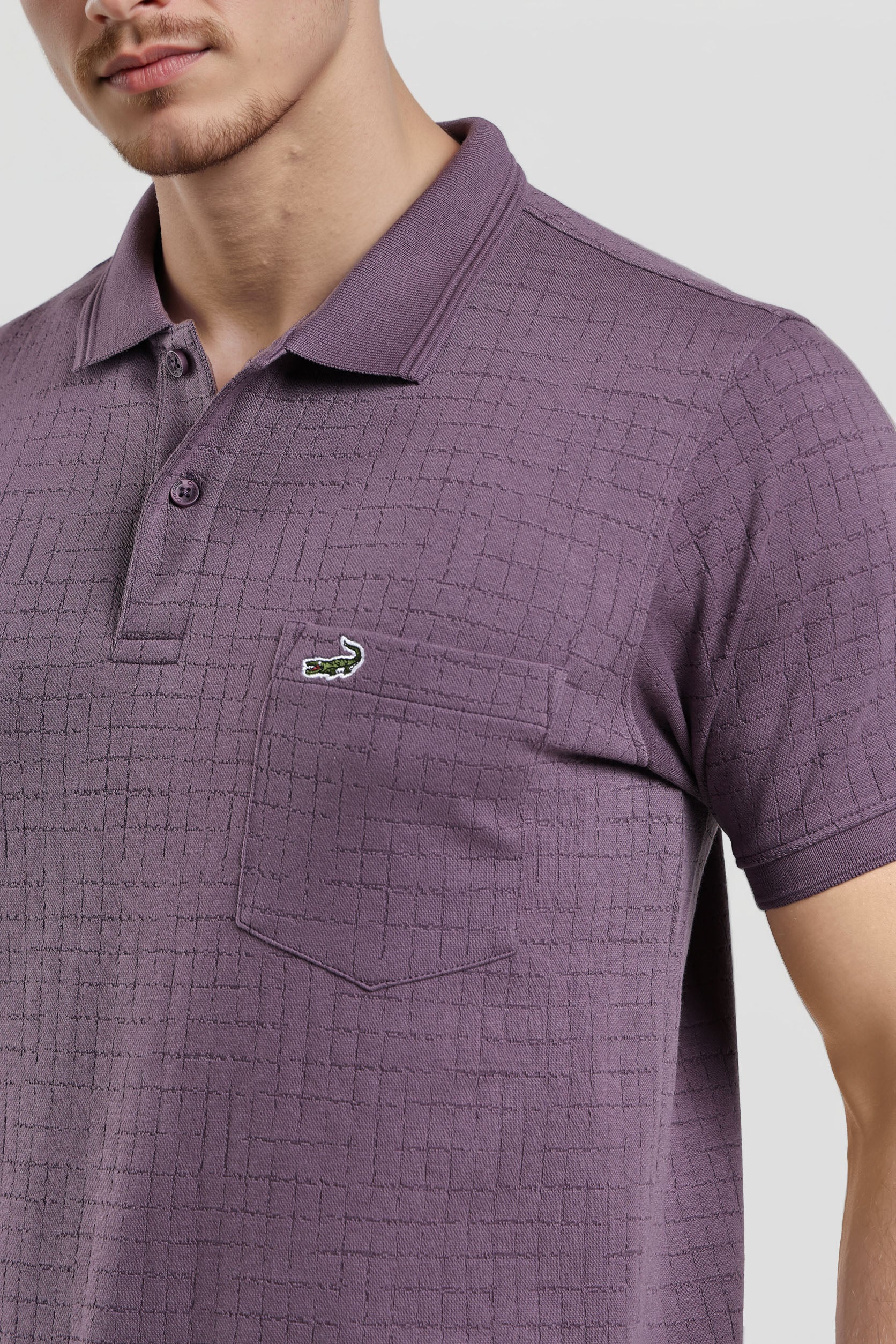 Purple checkered polo shirt with a brand logo on a light gray background