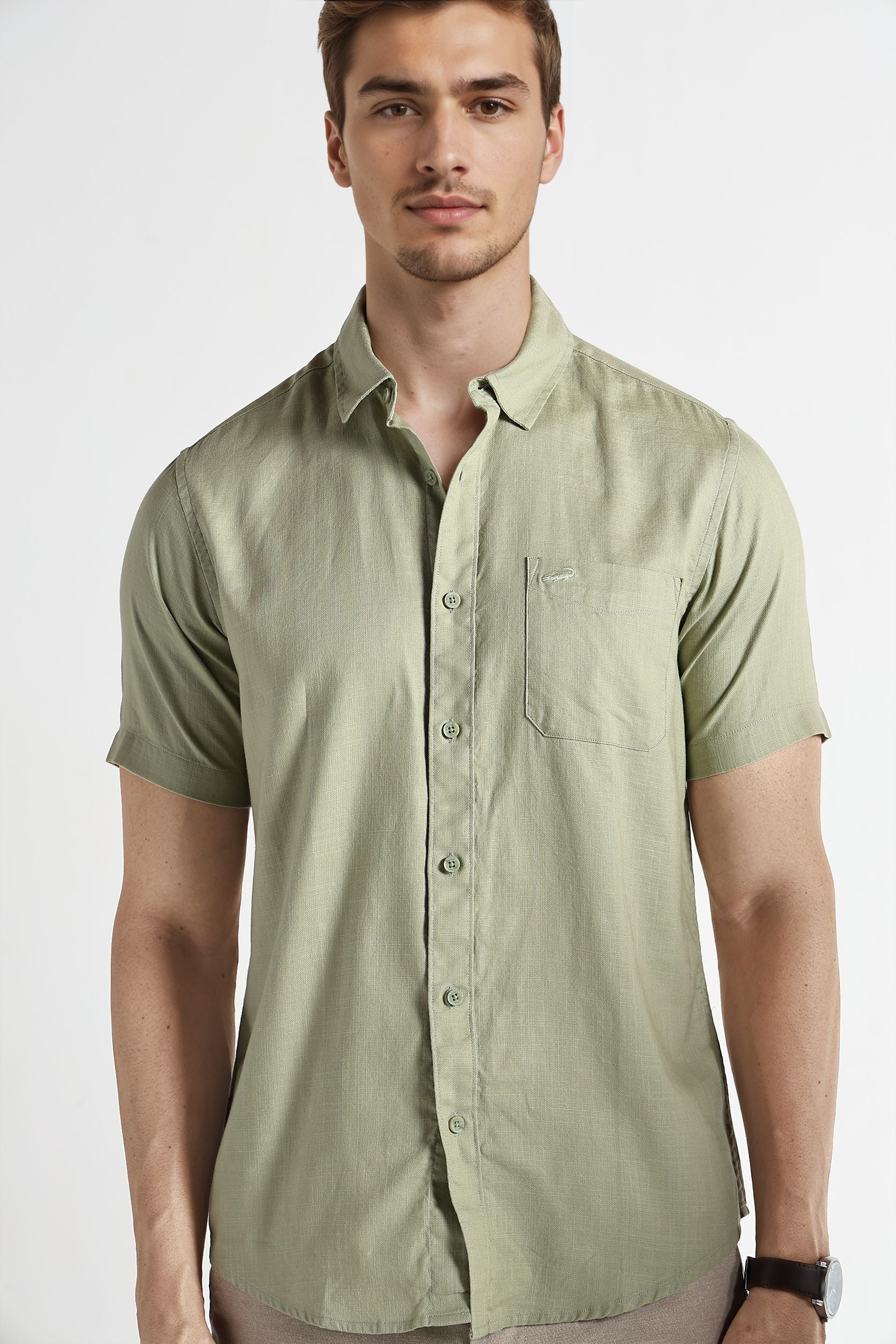 Man wearing a light green short-sleeve shirt on a white background