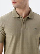 Man wearing a olive light olive structure comfort fit polo t shirt on a light gray background