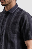 Man wearing a dark blue striped shirt against a white background