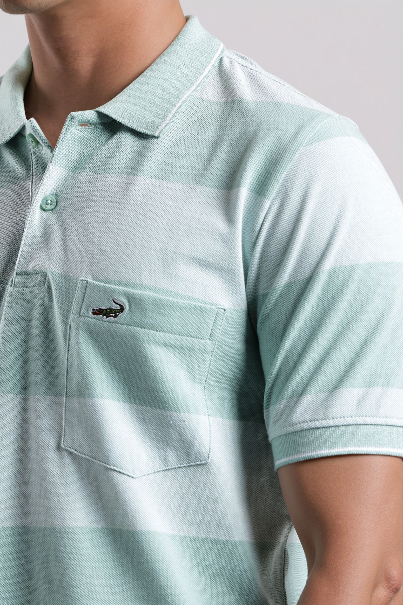 Light blue polo shirt with a brand logo on a neutral background