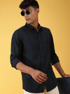Man wearing a green checked green casual full sleeve 100% cotton shirt with casual styling on a gray background