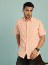 Man wearing a orange solid half sleeve 100% cotton shirt with casual styling on a gray background