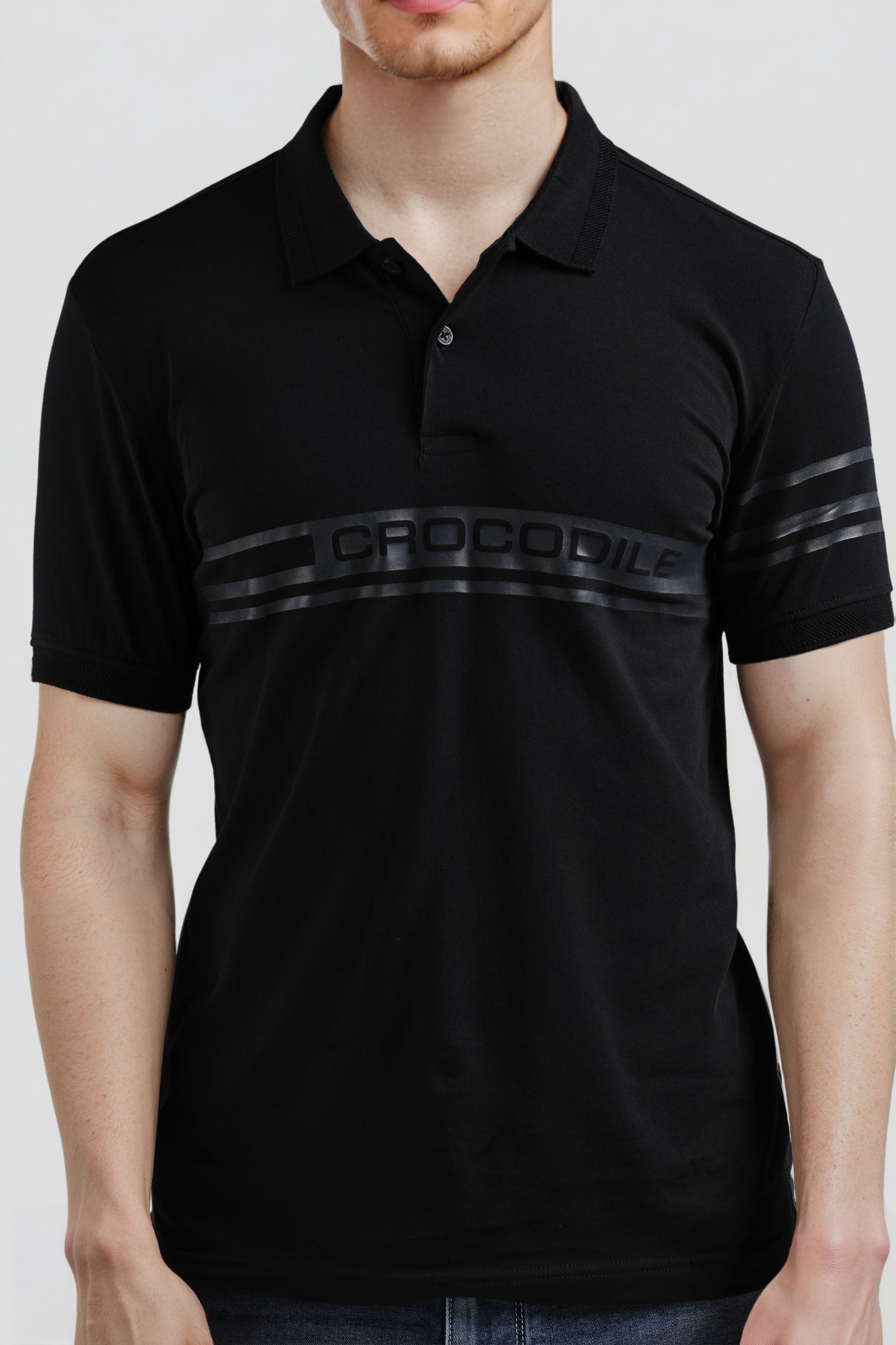 Black polo shirt with 'Crocodile' branding on a white background