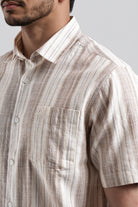 Close-up of a man wearing a patterned shirt with a neutral background