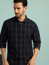 Man wearing a navy checked full sleeve casual 100% cotton navy shirt with casual styling on a gray background