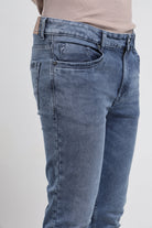 Blue jeans worn by a person on a white background