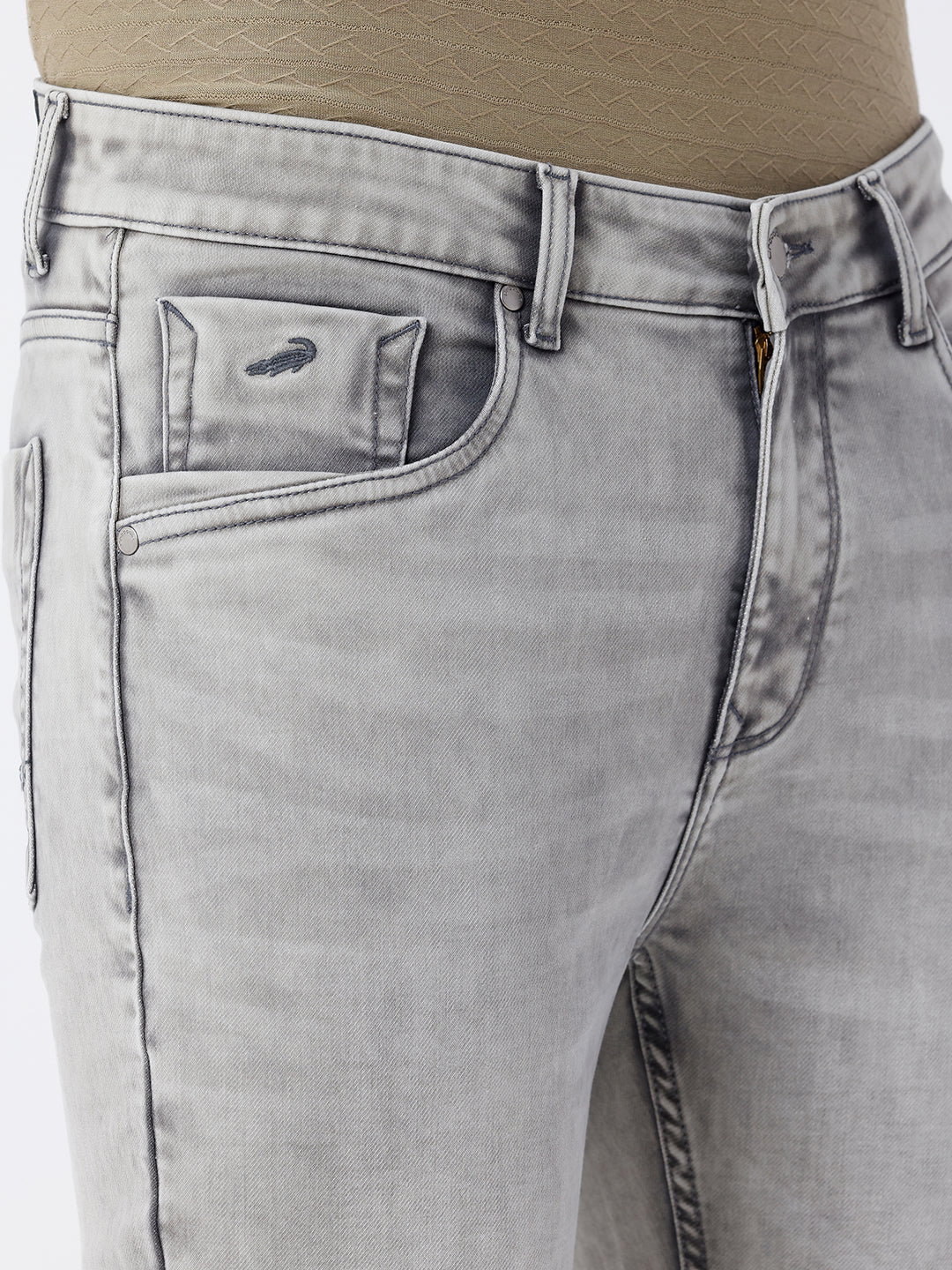 Man wearing a grey light grey knit slim fit jeans on a light gray background