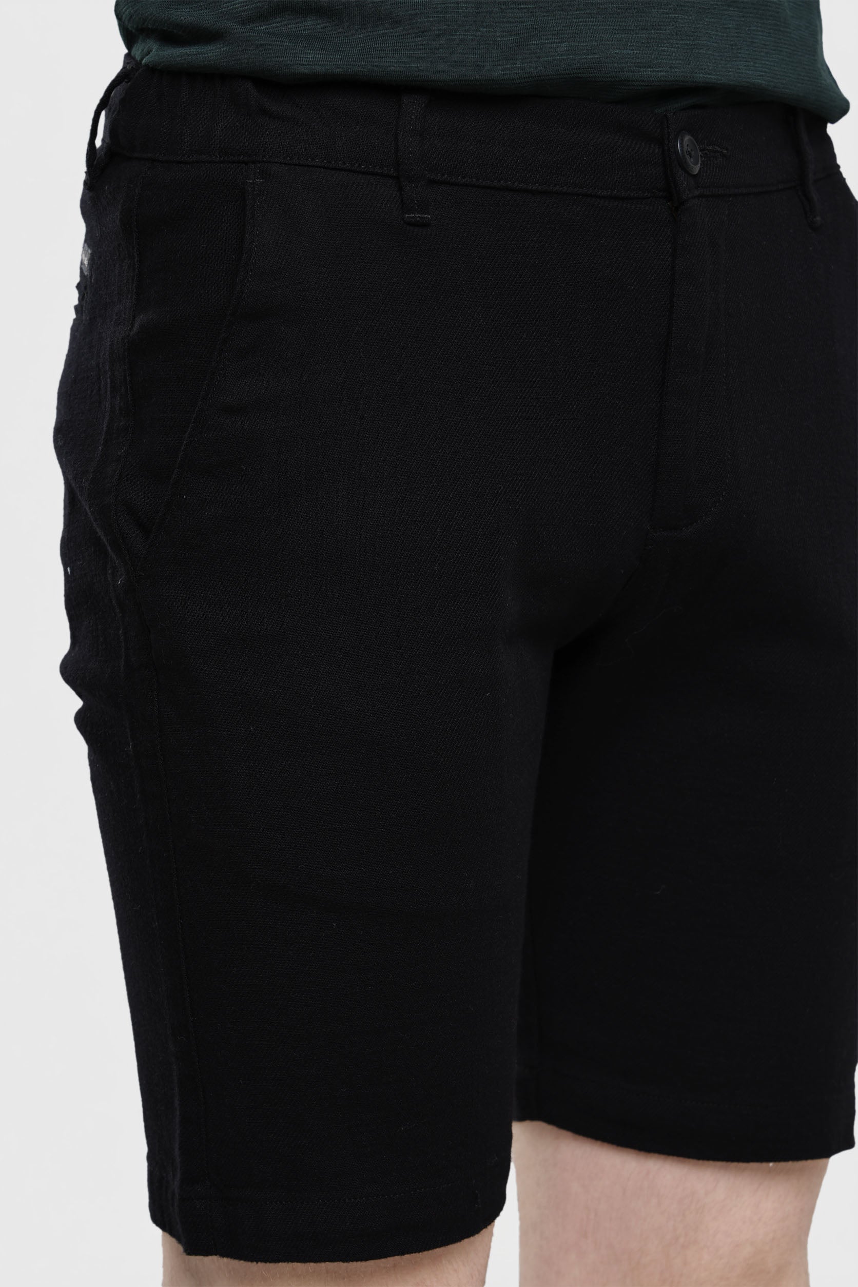 Black shorts worn by a person on a white background