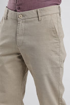 Beige pants with a button detail on a white background