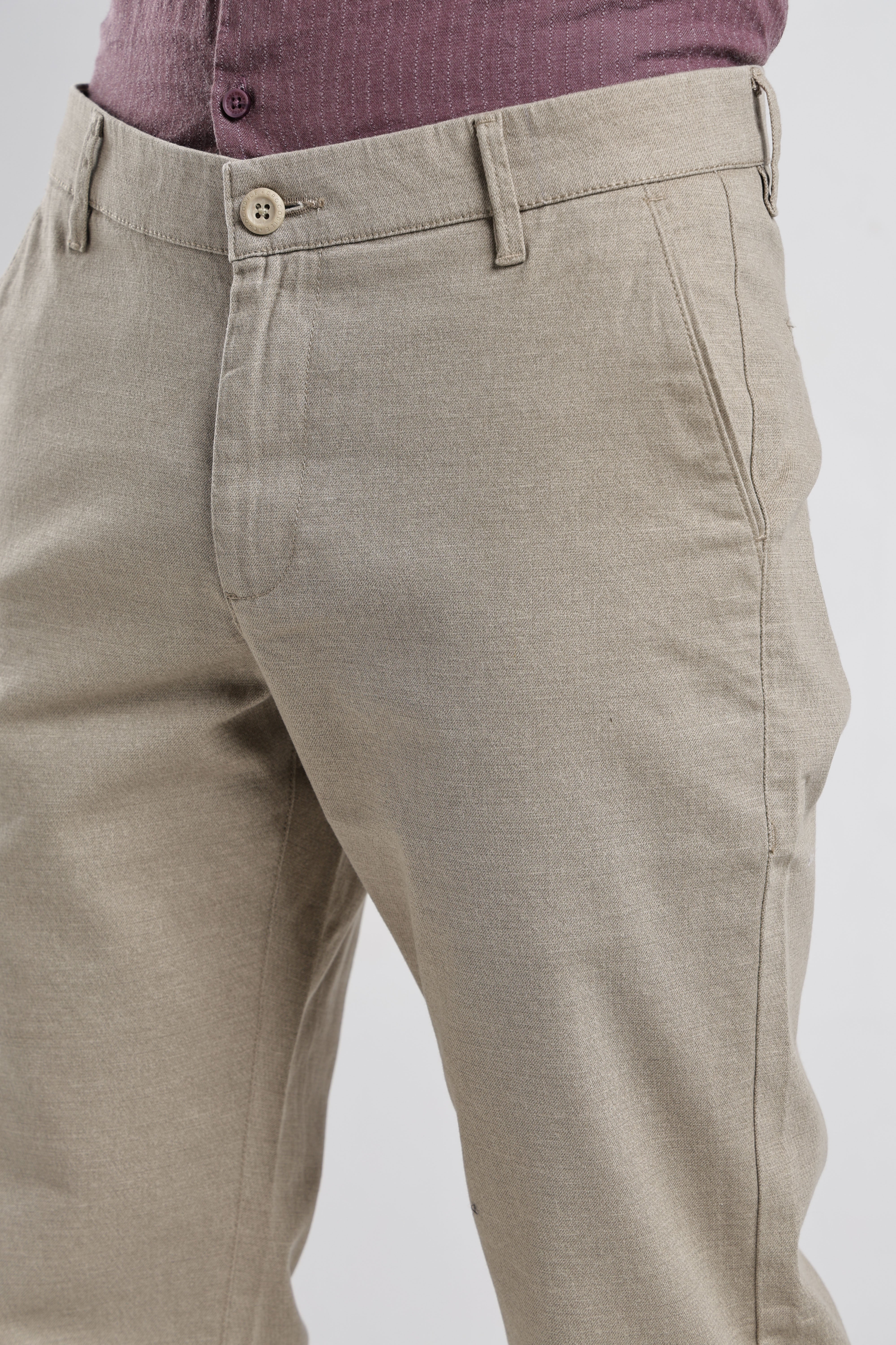 Beige pants with a button detail on a white background