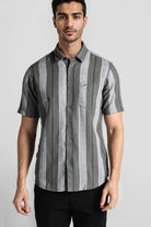 Man wearing a gray and black striped shirt on a white background