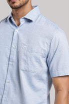 Light blue short-sleeve shirt worn by a person on a neutral background