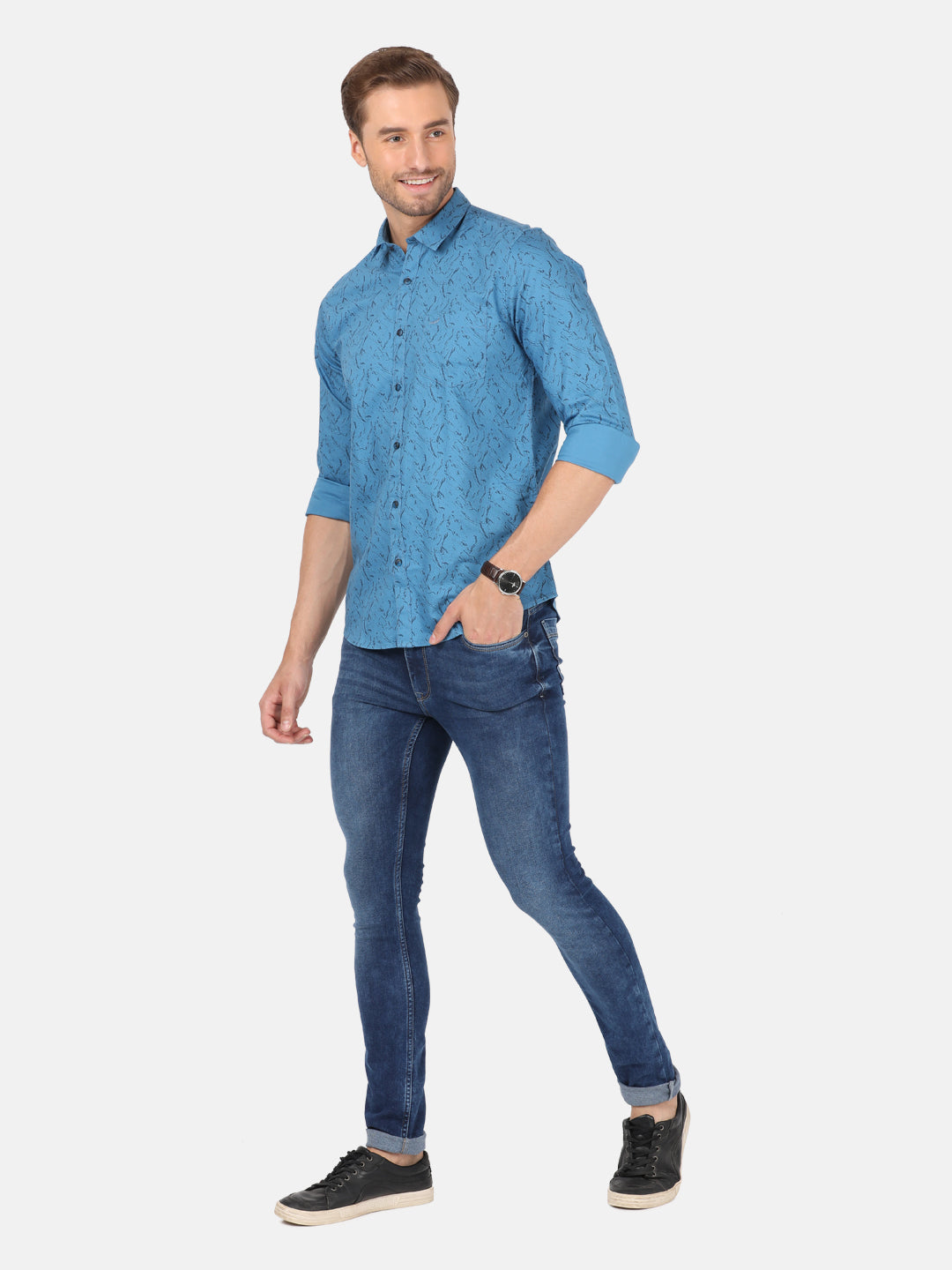 Man wearing a blue river blue printed full sleeve shirt on a light gray background