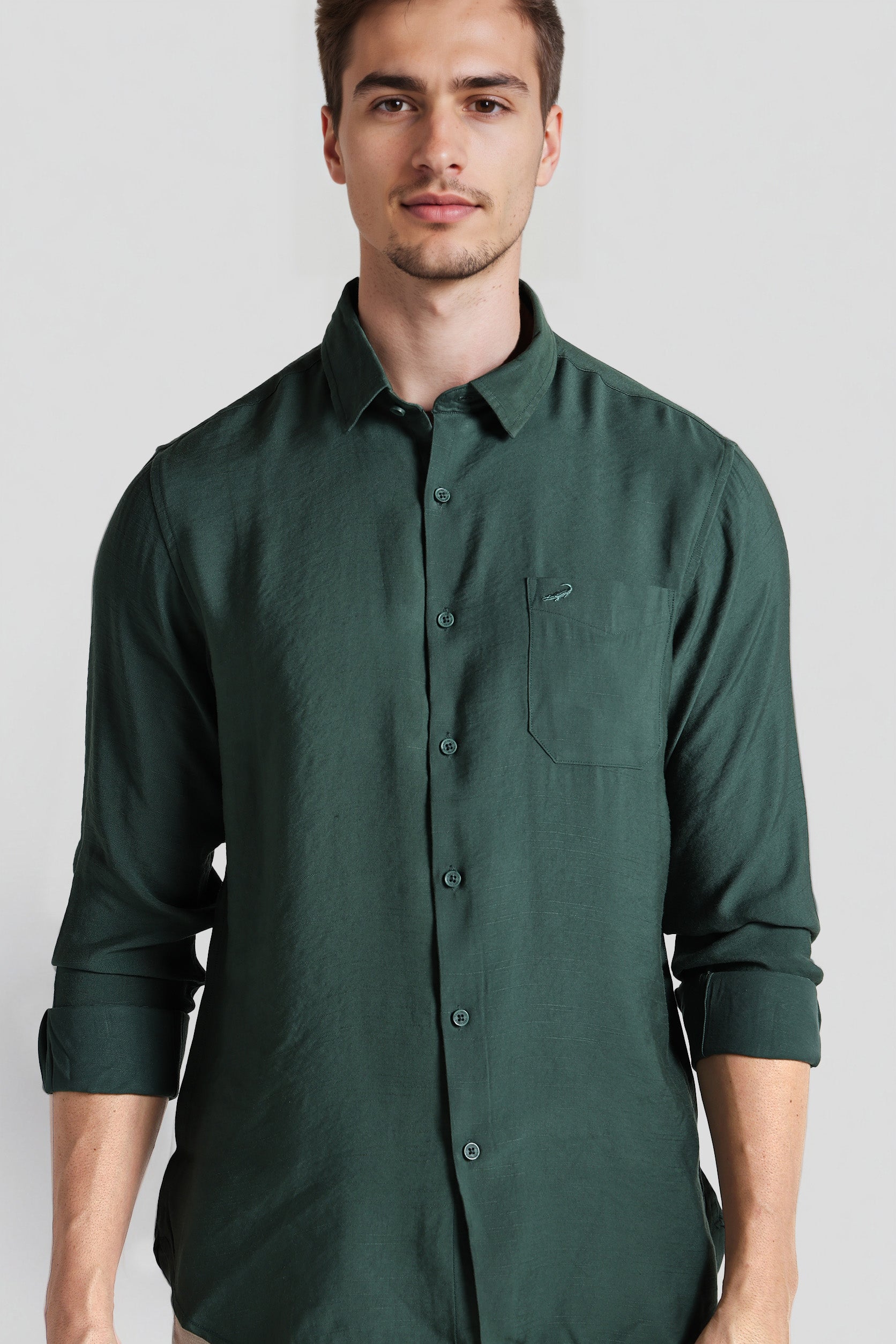 Man wearing a green shirt against a plain background