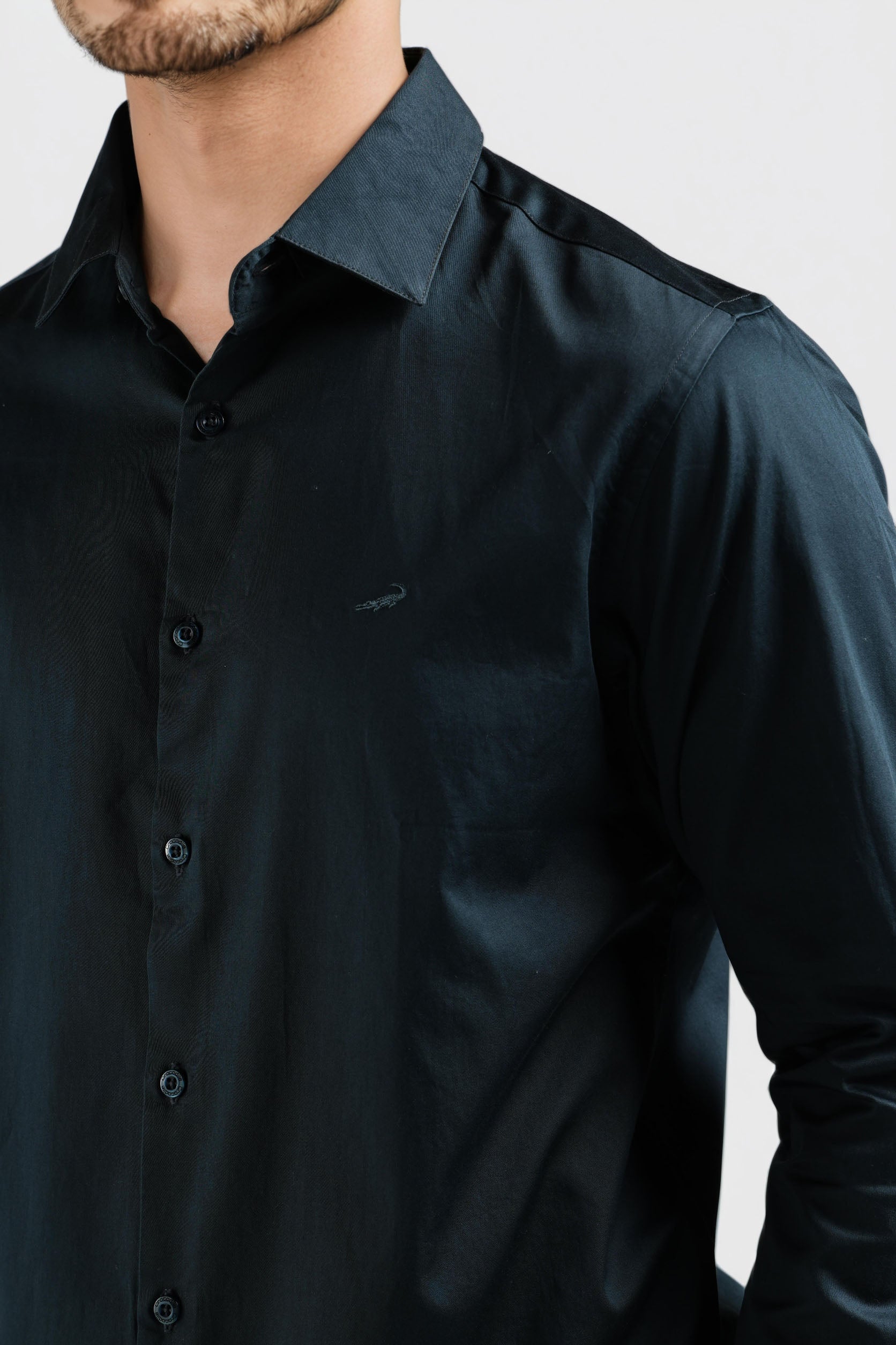 Black shirt worn by a person on a light gray background