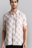 Man wearing a patterned shirt against a gray background