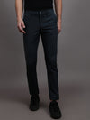 Man wearing a green dark teal green solid slim fit casual trouser on a light gray background