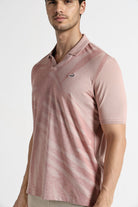 Man wearing a pink polo shirt with a brand logo on a white background