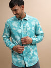 Man wearing a blue aqua blue printed full sleeve 100% cotton shirt on a light gray background