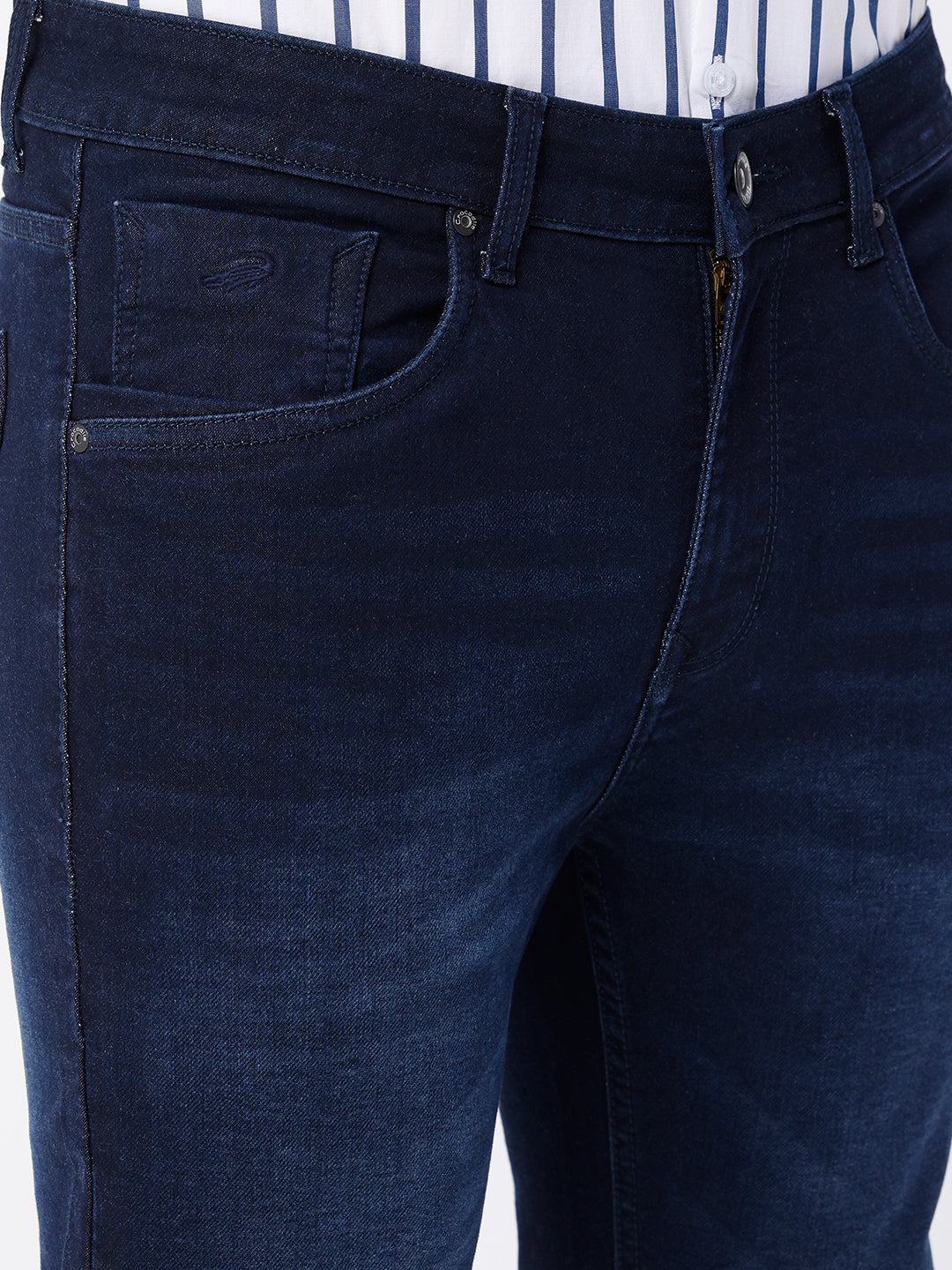 Man wearing a blue dark blue knit slim fit jeans with casual styling on a gray background