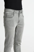 Gray jeans worn by a person on a white background