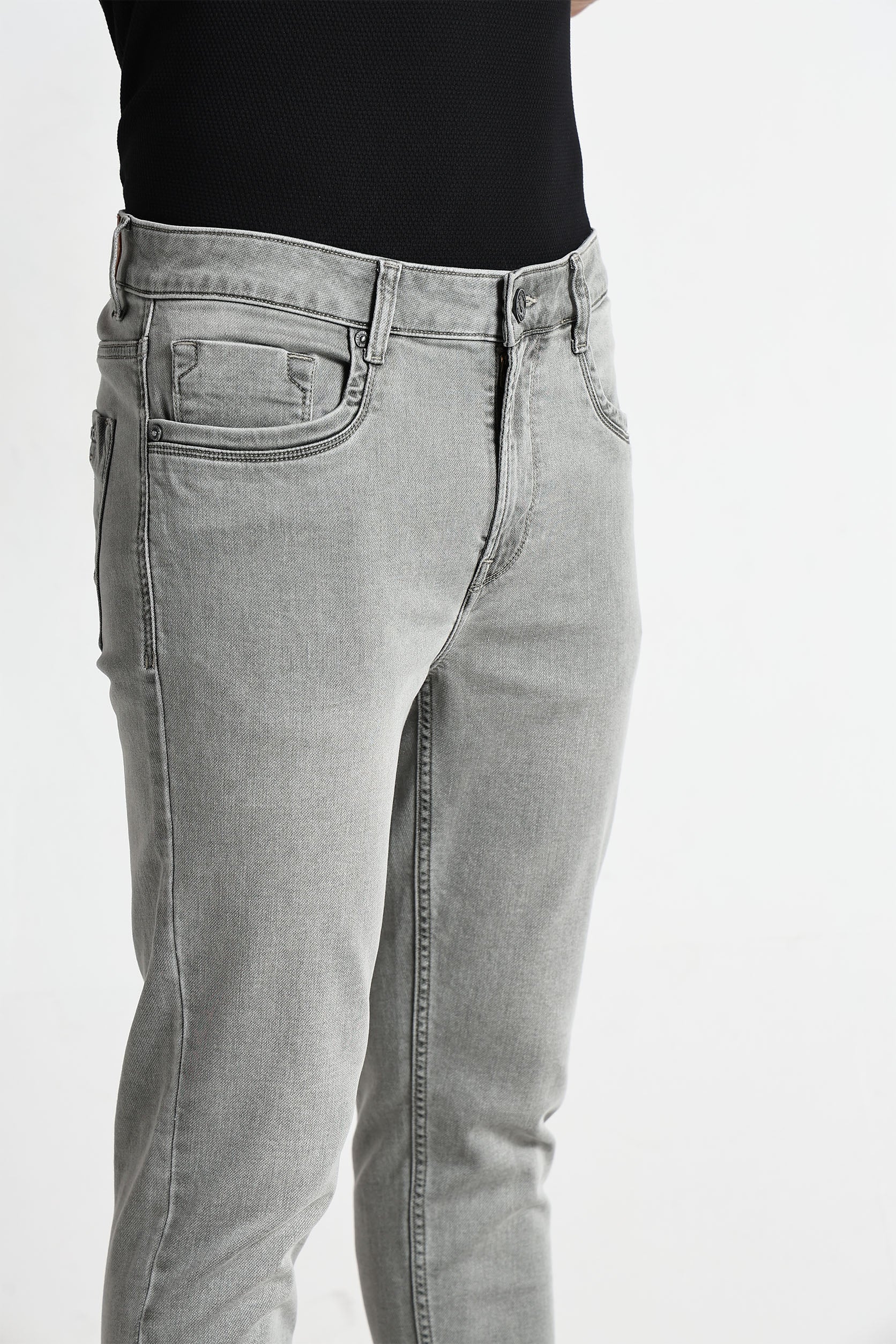 Gray jeans worn by a person on a white background
