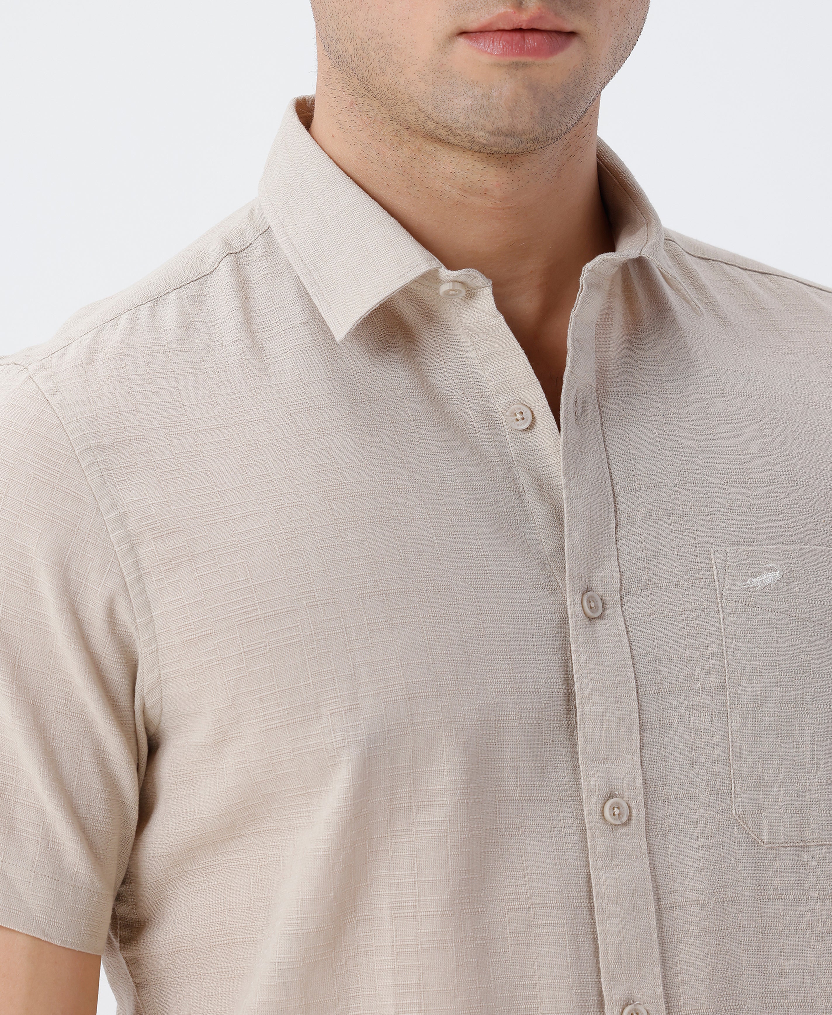 Man wearing a beige pure cotton textured shirt beige on a light gray background