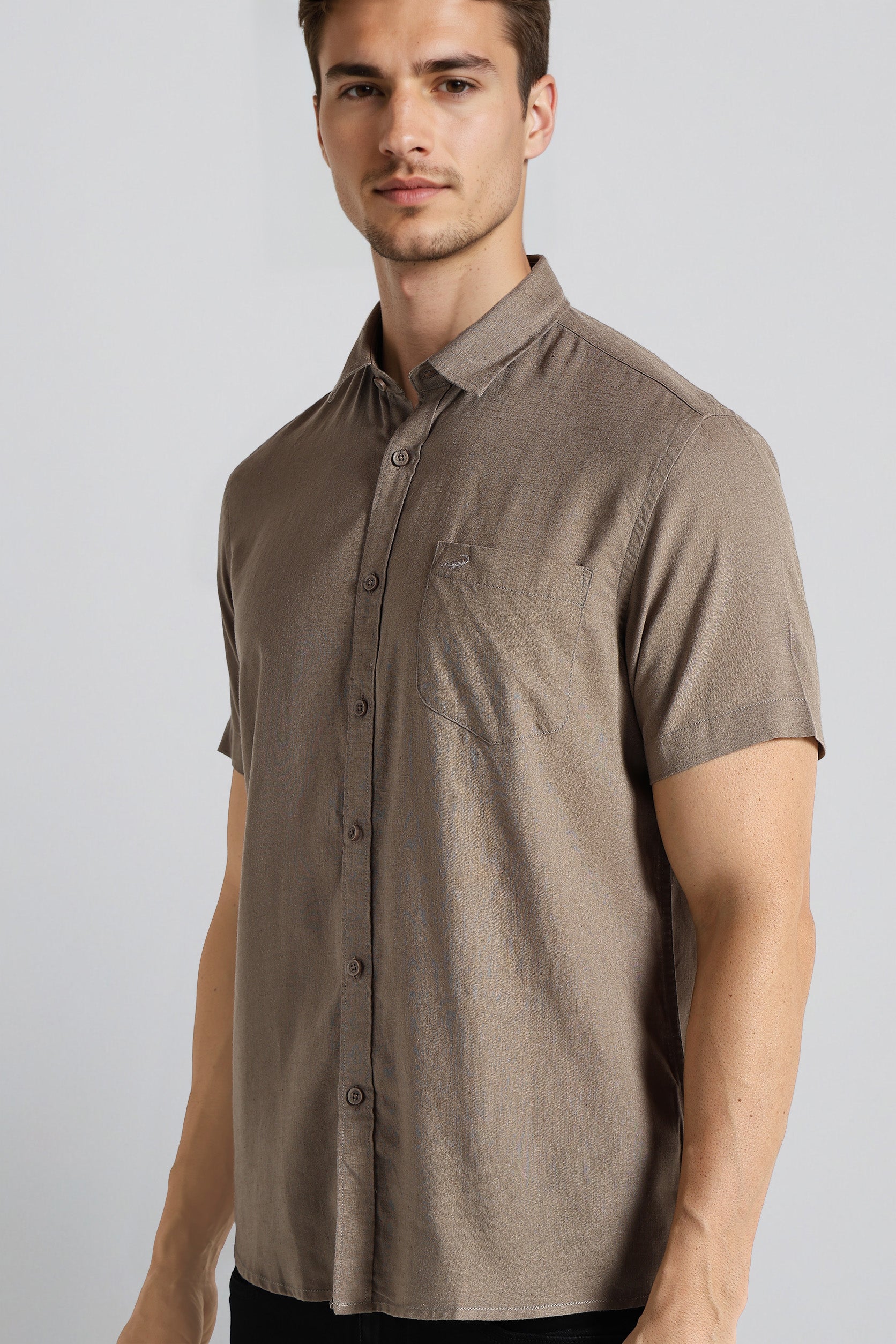Man wearing a brown short-sleeve shirt against a white background