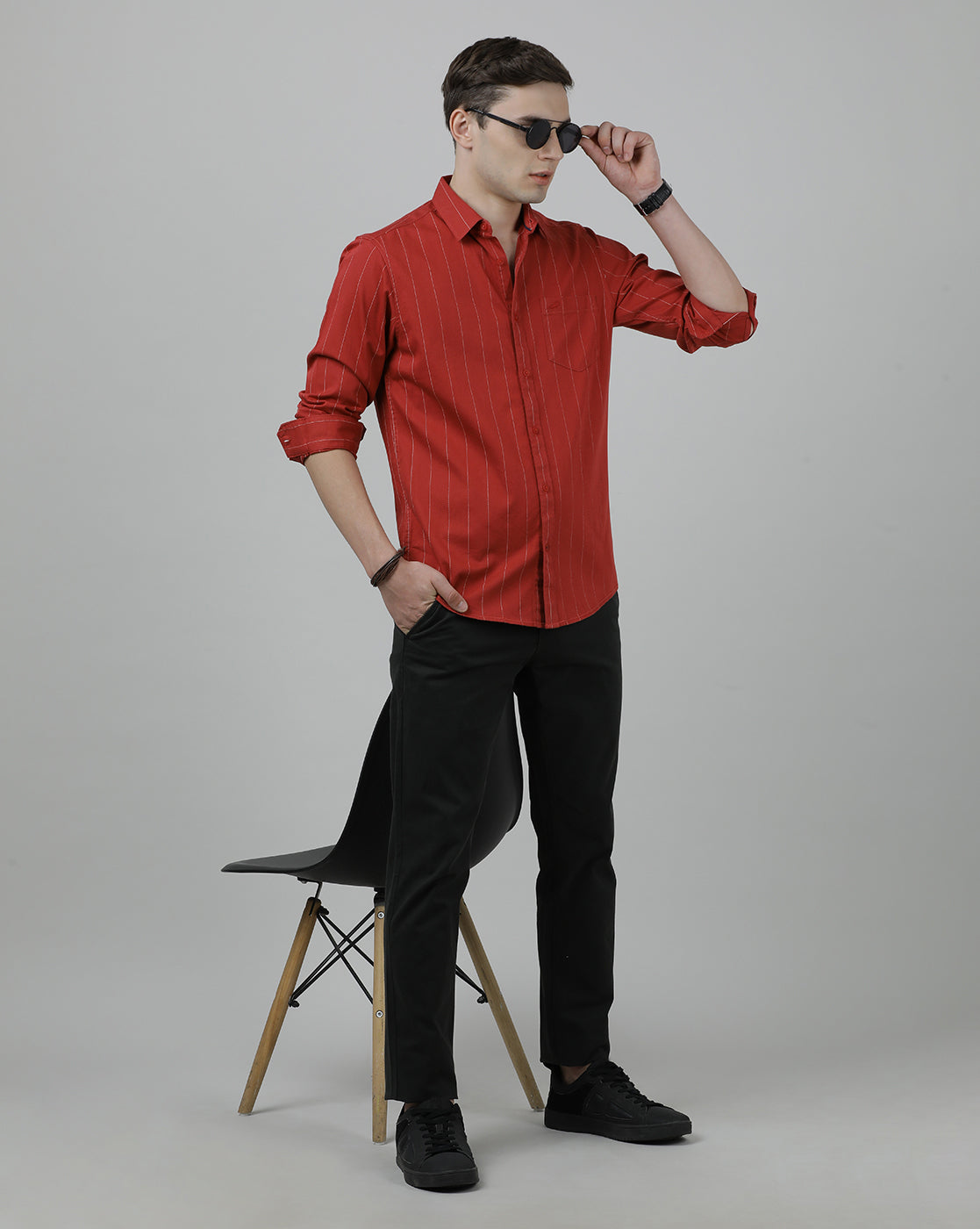 Man wearing a red red striped full sleeve 100% cotton casual shirt on a light gray background