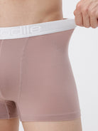 Person wearing boxer briefs with a visible brand logo on a plain background