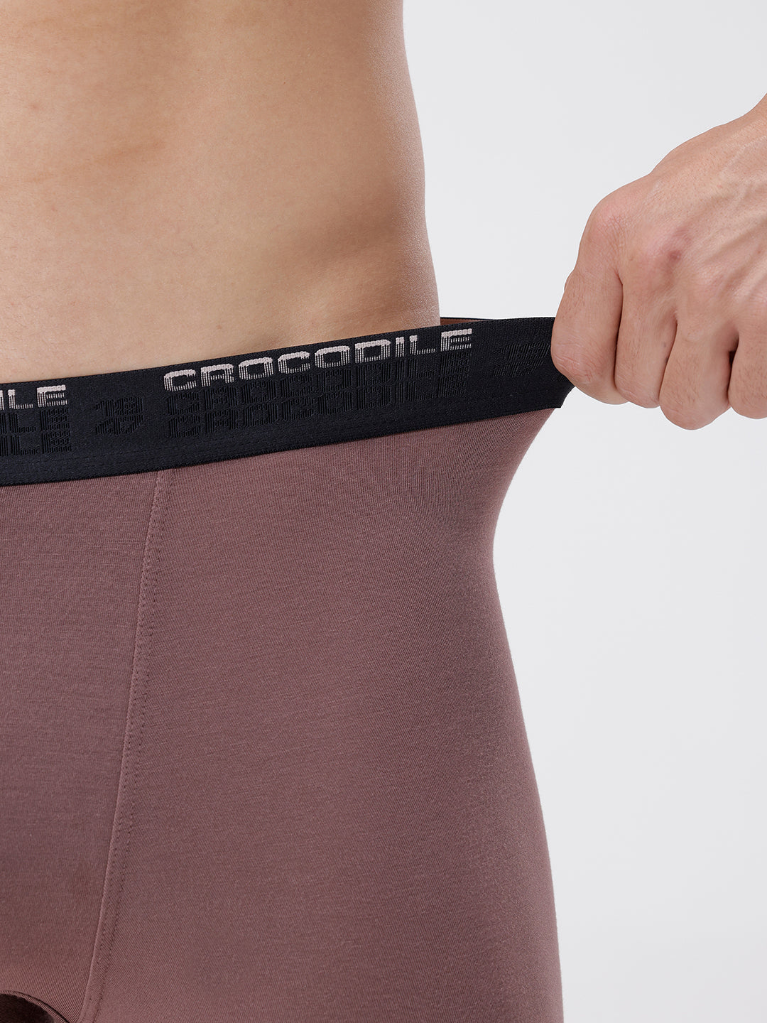Person wearing a brown athletic outfit with a black waistband featuring 'Crocodile' branding.