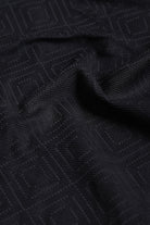 Close-up of black textured fabric with geometric pattern