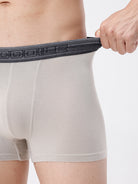 Person wearing light gray boxer briefs with a dark waistband, holding the waistband.