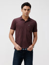 Man wearing a brown self structure solid polo t shirt brown with casual styling on a gray background