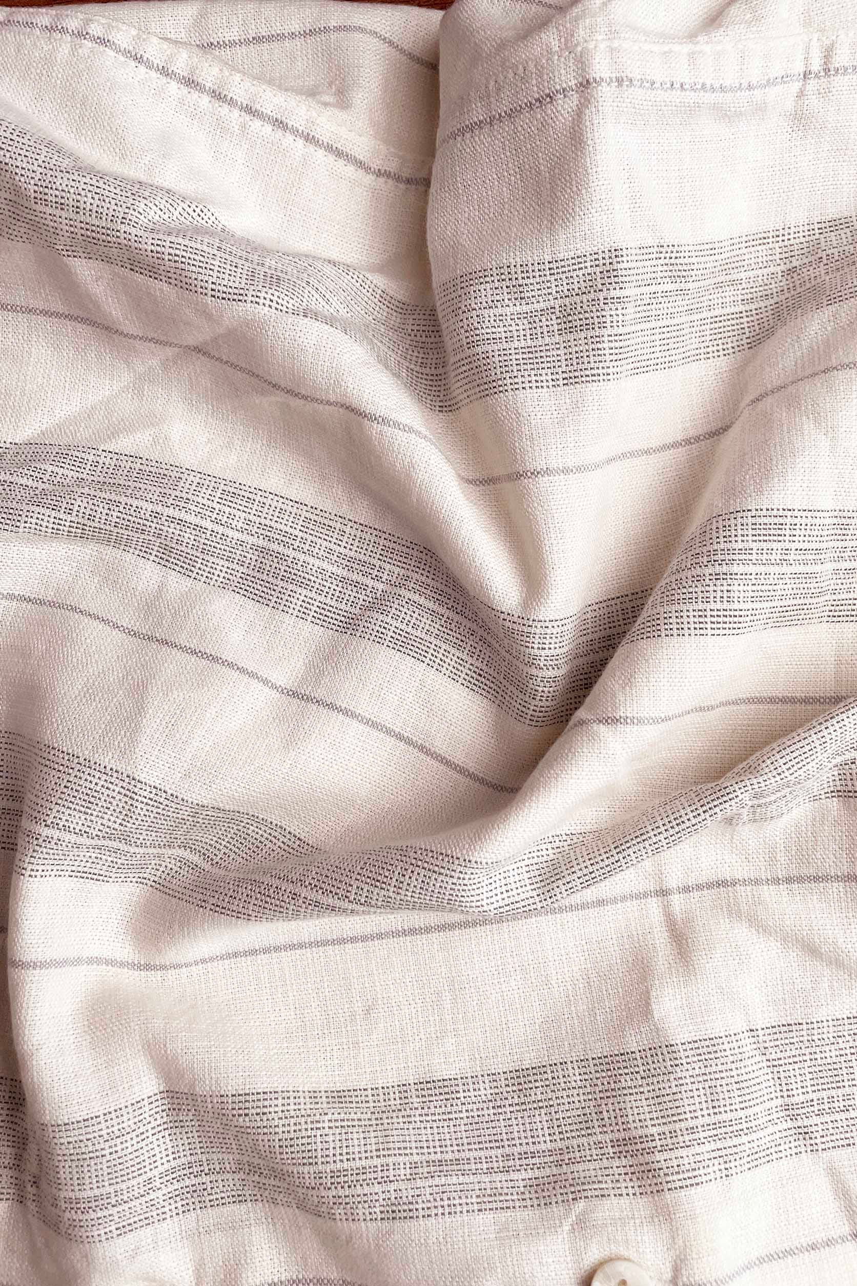 Close-up of white fabric with subtle black stripes