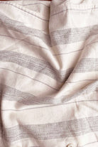 Close-up of white fabric with subtle black stripes