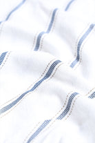 Close-up of white fabric with blue stitching