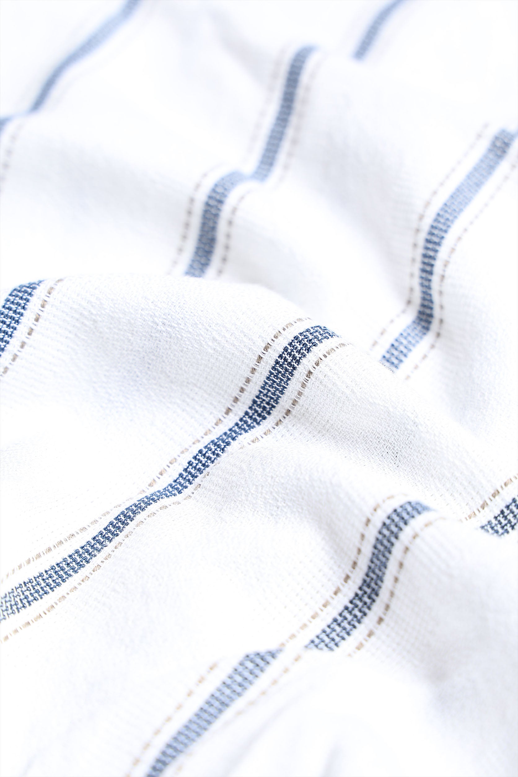 Close-up of white fabric with blue stitching