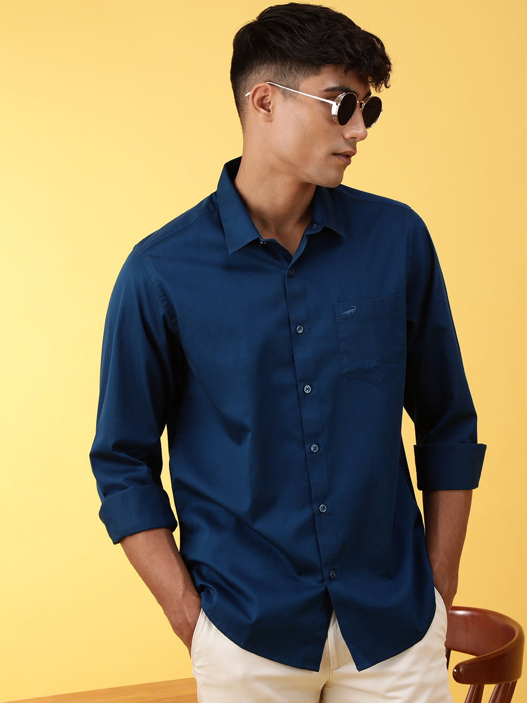 Man wearing a blue royal blue solid full sleeve 100% cotton casual shirt with casual styling on a gray background