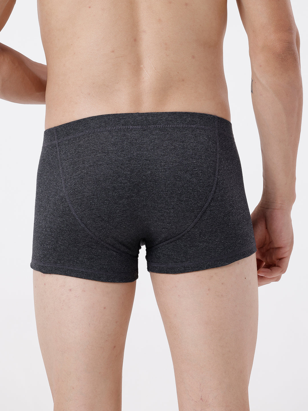 Person wearing dark gray boxer briefs on a plain background